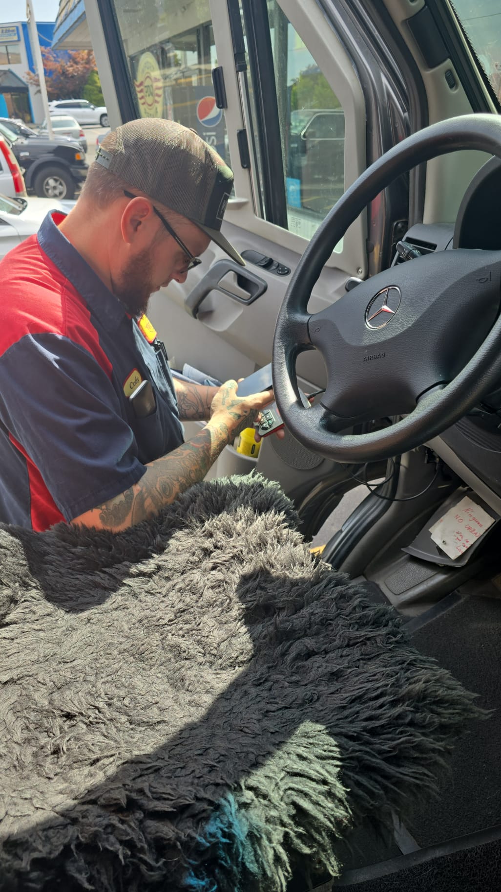 A PDQ technician at work inside an import van in the bay
